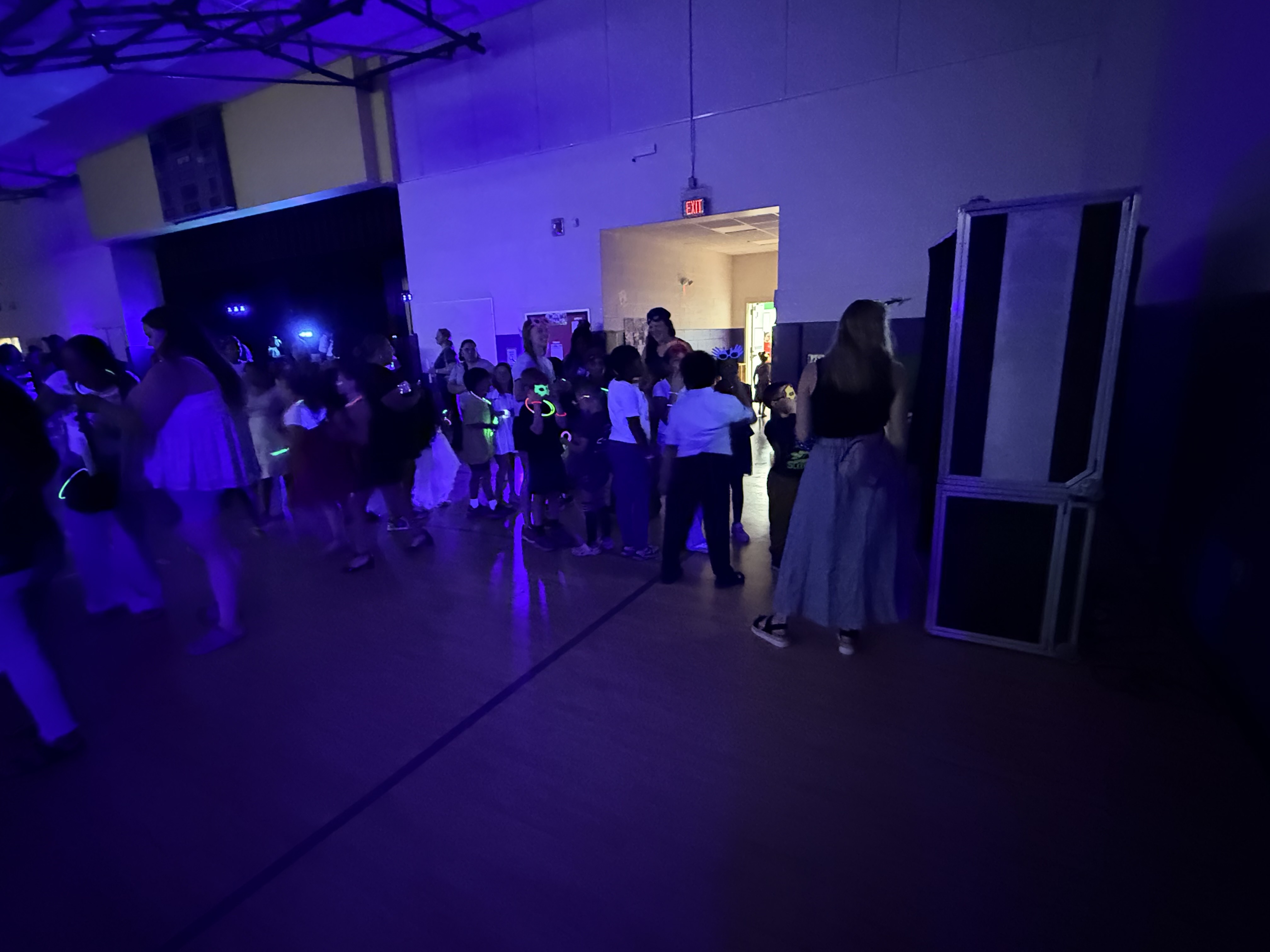 Kids wearing glow stick accessories on the dance floor near the Raleigh Photobooths booth
